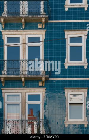 Farbenfrohe blaue Wohnhausfassade in Lissabon, Portugal, mit verzierten Balkonen, weißen Fensterrahmen und traditioneller Architektur. Stockfoto