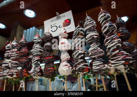 Schokoladenüberzogene Erdbeeren auf Spießen auf dem berühmten Markt La Boqueria in Barcelona Stockfoto
