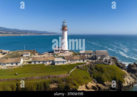 Luftaufnahme zeigt den Pigeon Point Leuchtturm neben Küstenhäusern entlang der felsigen Küste von Pescadero, Kalifornien, mit Blick auf den weiten Pazifik Stockfoto