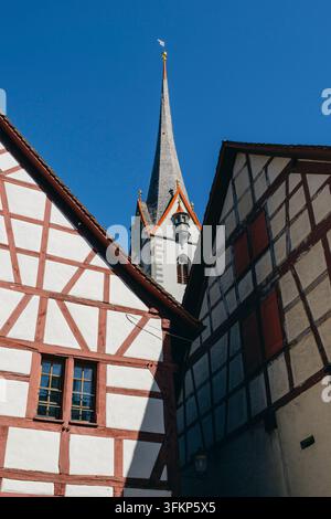 Historische Fachwerkhäuser mit dem charakteristischen Kirchturm im Hintergrund unter einem blauen Himmel, Blick von unten, Stein am Rhein, Kanton Schaffhausen Stockfoto