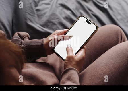 Frau verwendet ein Smartphone mit leerem weißem Bildschirm. Technologierückgrund für Mobiltelefon-App-Mockup-Kommunikation und digitales Leben. Stockfoto