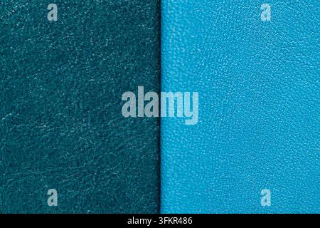 Eine Nahaufnahme-Makroansicht einer geteilten Oberfläche mit tiefem türkisfarbenem Leder auf der einen und lebhaftem hellblauem Leder auf der anderen Seite, beide mit einer feinen Stockfoto