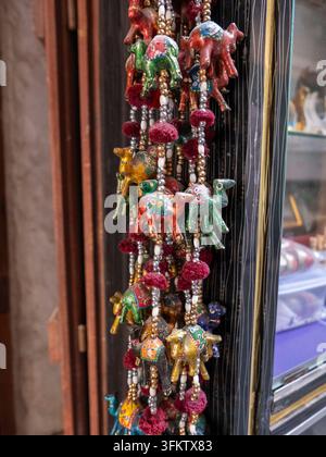 Bunte handgefertigte hängende Kamelornamente mit Perlen und Pompons, die zum Verkauf in einem Souvenirladen im Souq Waqif ausgestellt sind. Stockfoto