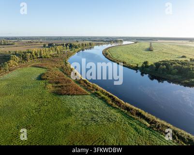 Luftbild des Svete-Flusses, der sich durch landwirtschaftliche Felder in der Nähe von Lielupe, Lettland, schlängelt Stockfoto