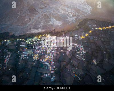 Luftaufnahme zeigt ein ruhiges Dorf, das sich an steilem Gelände neben Bromo befindet Stockfoto