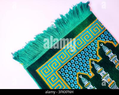 Grünes Gebetsteppich isoliert auf weißem Hintergrund. Stockfoto