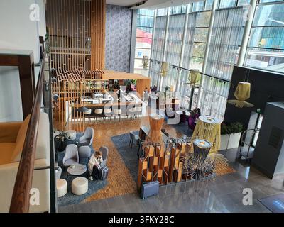 Hochwinkelaufnahme einer zeitgenössischen Luxus-Hotel-Lobby mit modernem Innendesign und einem stilvollen Barbereich, der durch Holzlattenverkleidungen akzentuiert ist, weiß Stockfoto