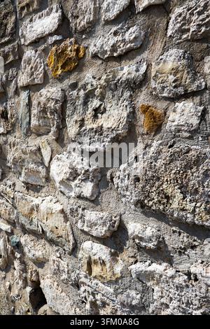 Verwitterte historische Steinwandtextur in Çeşme, Provinz Izmir, Türkei Stockfoto