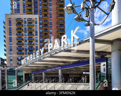 London, Vereinigtes Königreich - 10. Juni 2026: Große weiße Buchstaben WEMBLEY PARK auf einem Dach über dem Eingang der Wembley Park Station mit Treppen und Geländern, Stockfoto