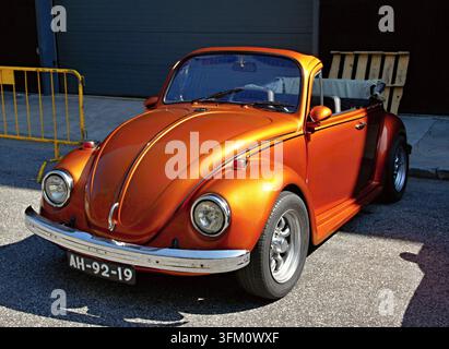 Angepasstes orangefarbenes Volkswagen Beetle Cabriolet, das in der Sonne geparkt ist Stockfoto