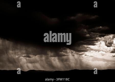 Schwarz-weiße Wolken und Regen über einer weiten Landschaft, eine ruhige und gedämpfte Atmosphäre, Maestrazgo (Maestrat, Alto Maestrazgo, l'Alt Maestrat), Spanien Stockfoto