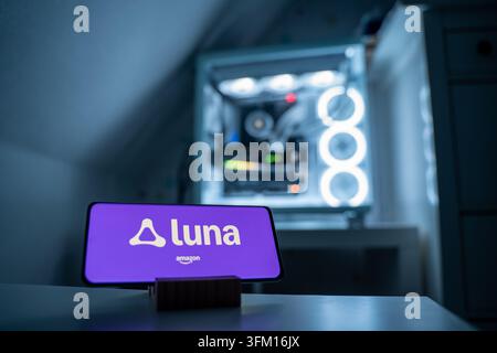 Das Amazon Luna-Logo wird auf einem Smartphone angezeigt. Der Cloud-Gaming-Dienst wird von Amazon angeboten. Im Hintergrund ist ein Gaming-PC sichtbar, 18.01.2026. Stockfoto