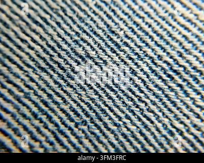 Eine Super-Makro-Nahaufnahme, die das verwobene Gewebe und die Fasern von blauem Denimstoff zeigt. Stockfoto