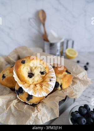Frische hausgemachte Blaubeermuffins, serviert in einer rustikalen Backform mit frischen Blaubeeren Stockfoto
