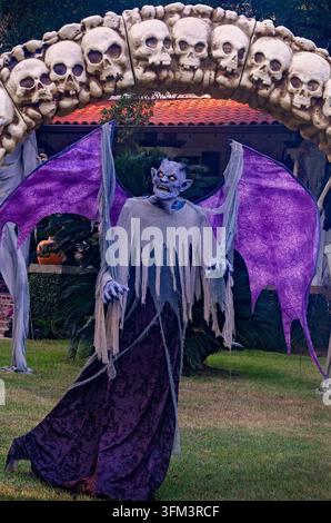 Mobile, Alabama, USA - 28. Okt. 2024: Ein lila Dämonenmonster steht vor einem historischen Haus, das für Halloween in Mobile, Alabama, dekoriert ist. Stockfoto