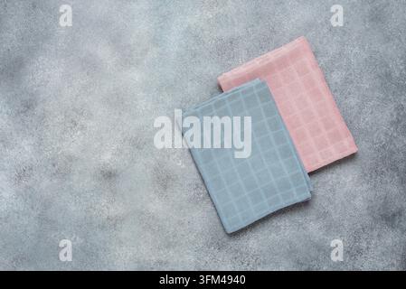 Pinke und blaue Baumwollservietten auf grauem Beton-Hintergrund. Draufsicht, flach liegend. Stockfoto