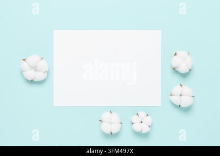 Hochzeitskarte mit Baumwollblumen auf pastellblauem Hintergrund. Draufsicht, flach liegend. Schreibwaren Sommer Stillleben Stockfoto