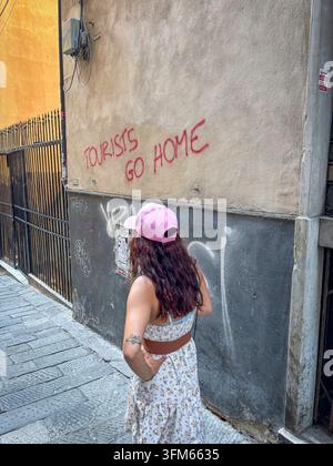 GENUA, ITALIEN - 2025/08/13: Eine Sommerwoche von Genua nach Florenz über Pisa und Vinci, in den Massen des Massentourismus. Ein Tourist geht an einem Touri vorbei Stockfoto