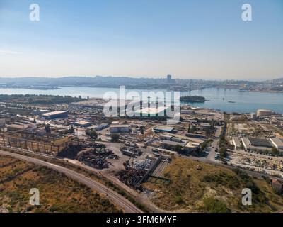 SPLIT, KROATIEN - 9. SEPTEMBER 2026 Luftansicht eines industriellen Ufergebiets mit Eisenbahngleisen, Lagerhallen, Schrottstapeln und Hafen. CEMEX wird als con geliefert Stockfoto