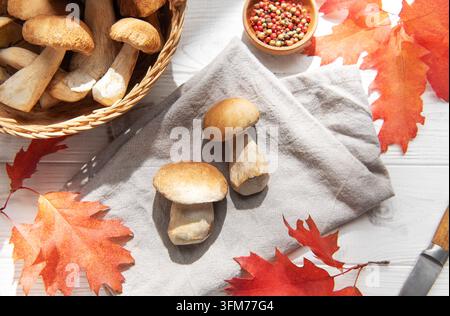 Frisch gepflückte Steinpilze auf einem Holztisch mit Herbstblättern Stockfoto