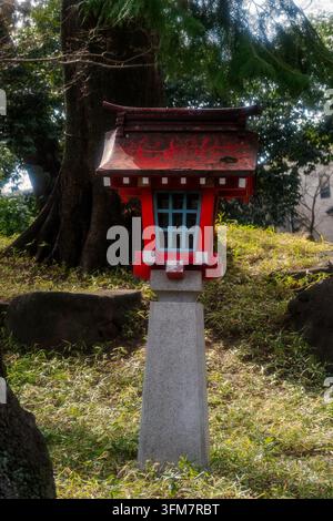 Ein traditioneller roter japanischer Stein- und Holzlaterne, bekannt als Tōrō, häufig zu finden an Shintō-Schreinen und buddhistischen Tempeln. Stockfoto
