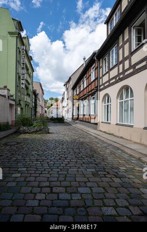 Eine schmale Kopfsteinpflasterstraße mit historischen Fassaden und Geschäften in Berlin-Spandau Stockfoto