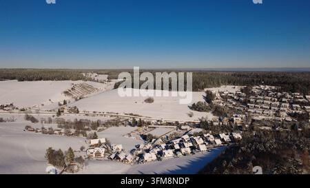 Winterlandschaft auf dem Land in Deutschland mit schneebedeckten Feldern, entfernten Häusern, Straßen und ländlicher Szenerie an einem kalten Novembertag. Stockfoto