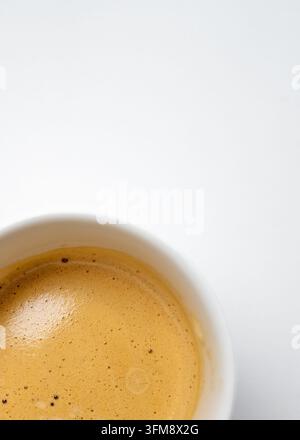 Tasse frisch zubereitetes Espresso mit goldener Crema, von oben gesehen vor weißem Hintergrund. Perfekt für Café-Promotionen, Speisekarten, Verpackungen Stockfoto