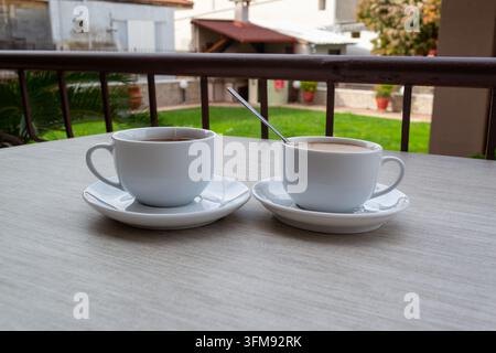 Zwei Tassen Tee und Kaffee auf einem Außentisch Stockfoto