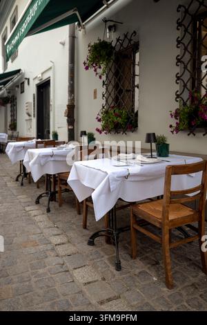 Weiß gedeckte Restauranttische in einem ruhigen Innenhof im Bezirk Kazimierz arrangiert. Stockfoto