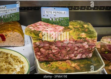 Traditionelle französische Tête persillée aus Schweinefleisch mit frischer Petersilie an einem handwerklichen Metzgerstand auf einem provenzalischen Bauernmarkt in Antibes, Frankreich Stockfoto