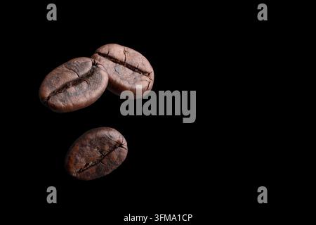 Nahaufnahme von dunklen, aromatischen Samen, die zum Brauen von Espressogetränken verwendet werden, mit einer reichen Textur und natürlichen organischen Mustern, isoliert auf dunklem Raum Stockfoto