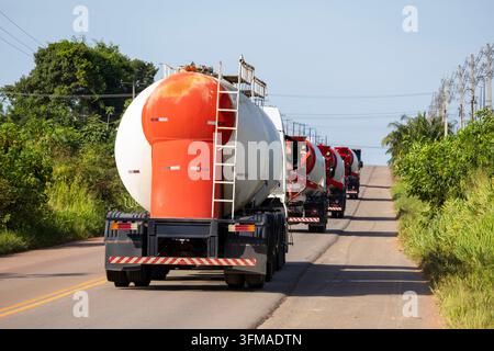 Industrielle Logistik und Frachttransport: eine Reihe von gewerblichen Frachttrucks auf einer offenen Straße. Stockfoto