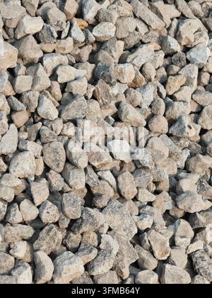 Eine Nahaufnahme von strukturierten Kiessteinen mit einer Mischung aus grauen und beigen Tönen, die eine natürliche, erdige Komposition erzeugen Stockfoto