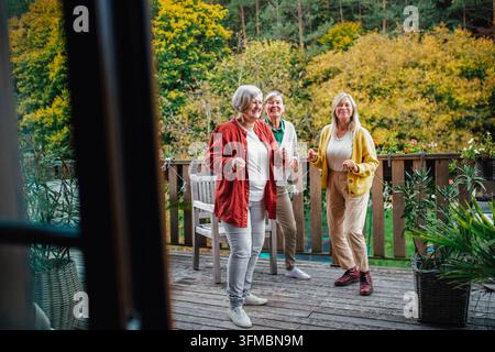 Seniorinnen genießen Freundschaft und einen Herbsttag auf der Terrasse. Stockfoto