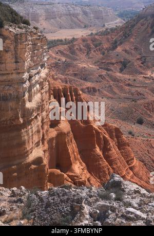 Rote und braune Klippen erheben sich steil in Rambla Barrachina, Teruel, Spanien, und unterstreichen die Schönheit der Natur. Stockfoto