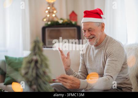 Alter Mann macht Videoanruf zu Weihnachten mit der Familie während der Feiertage zu Hause. Stockfoto