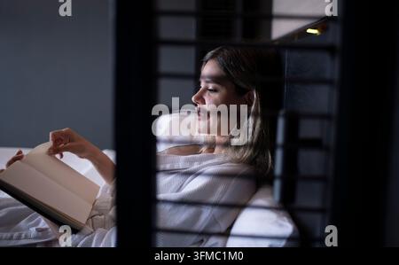 Glückliche junge Frau im Bademantel im Hotel ist ein Urlaubskonzept zur Entspannung. Stockfoto