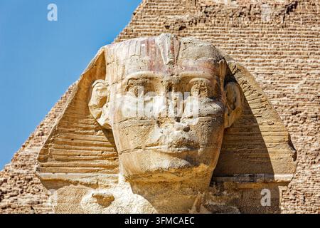 GIZA, ÄGYPTEN – 9. MÄRZ 2026: Nahaufnahme des Gesichts der Großen Sphinx von Gizeh mit Spuren von rotem Pigment auf dem Nemes-Kopfschmuck; das Mauerwerk des Py Stockfoto
