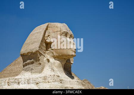 GIZA, ÄGYPTEN – 9. MÄRZ 2026: Profil des Kopfes der Großen Sphinx von Gisa vor einem tiefblauen Himmel, mit der Pyramide von Chephren im Hintergrund. Datierend aus t Stockfoto