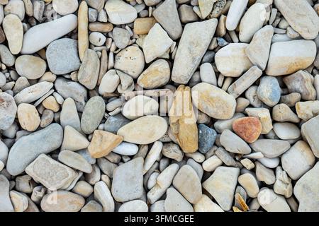 Flacher Hintergrund aus glatten bunten Flusssteinen Stockfoto