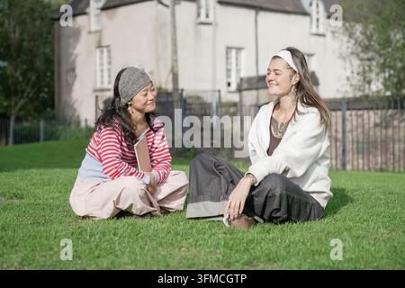 Verschiedene junge Frauen lächeln bei einem Gespräch im Freien Stockfoto