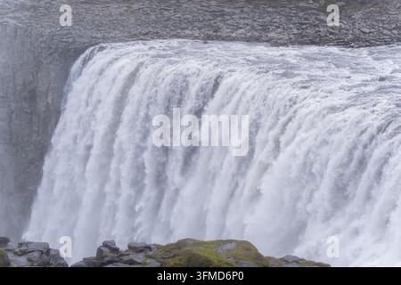 Mächtiges strömendes Wasser des Dettifoss-Wasserfalls, das über felsige Klippen im Vatnajökull-Nationalpark in Island stürzt. Stockfoto