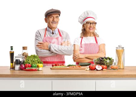 Senior Mann und Frau schneiden frisches Gemüse, isoliert auf weißem Hintergrund Stockfoto