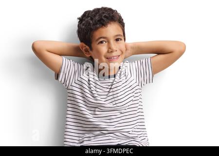 Junge in einem gestreiften T-Shirt, der lächelt, mit den Händen hinter dem Kopf Stockfoto