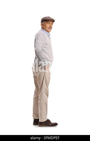 Älterer Mann mit flacher Kappe und Pullover im Profil stehend und zurückblickend Stockfoto