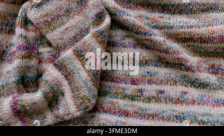 Intime Ansicht von strukturiertem, handgestricktem Stoff mit gemischten Farben und einem weichen, angenehmen Gefühl. Stockfoto