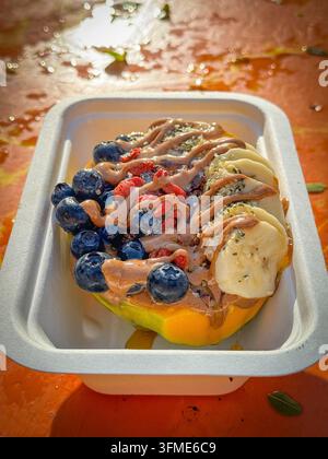 Papaya-Bowl-Frühstück serviert in einer halben Papaya mit glutenfreier Granola, Bananen, Blaubeeren, Kokosflocken, Goji-Beeren, Hanfsamen, Chiasamen, ca Stockfoto