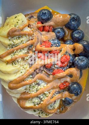 Papaya-Bowl-Frühstück serviert in einer halben Papaya mit glutenfreier Granola, Bananen, Blaubeeren, Kokosflocken, Goji-Beeren, Hanfsamen, Chiasamen, ca Stockfoto