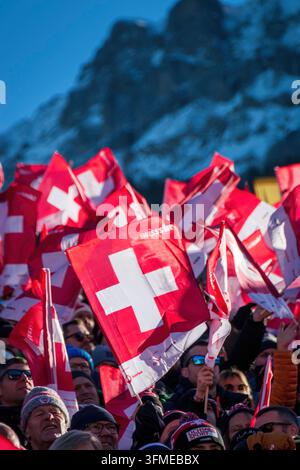 Adelboden, Schweiz - 7. Januar 2023: Ein Meer von Flaggen, die die Schweizer Unterstützung durch Tausende von Fans beim Alpinen Skiweltcup gegen den schneebedeckten Berg zeigen Stockfoto